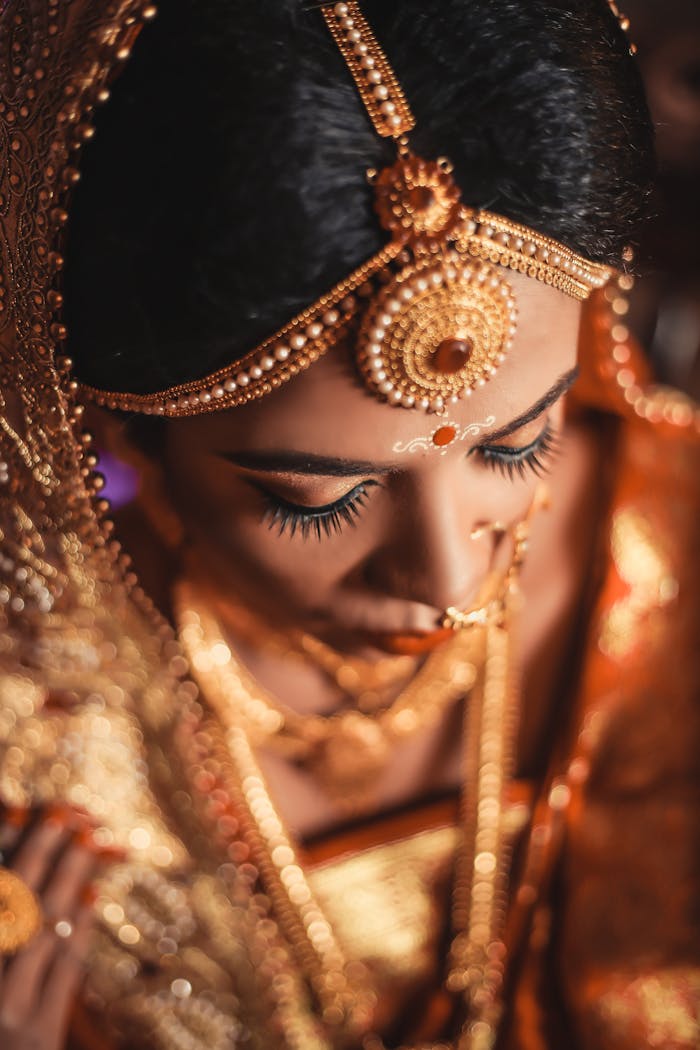 Close-up of a Bengali bride adorned with gold jewelry and traditional attire in Dhaka, Bangladesh.